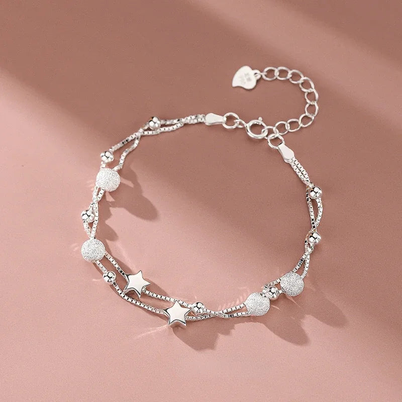 Close-up of the Serena Delicate Silver Bracelet clasp, heart tag and star charms