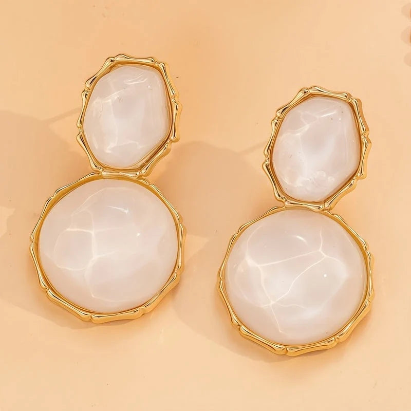 Bali Oval Resin Drop Earrings worn on wrist – White