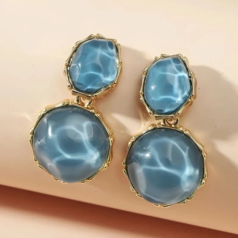 Bali Oval Resin Drop Earrings worn on wrist – Blue