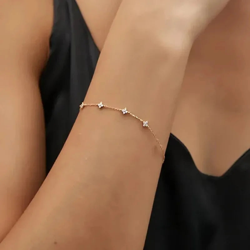 Woman wearing the Fiora Crystal Blossom Bracelet in gold, close-up on wrist