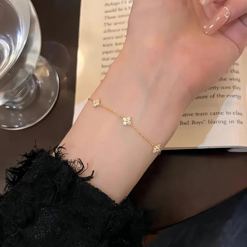 Fiora Crystal Blossom Bracelet in gold worn on wrist, lifestyle detail shot